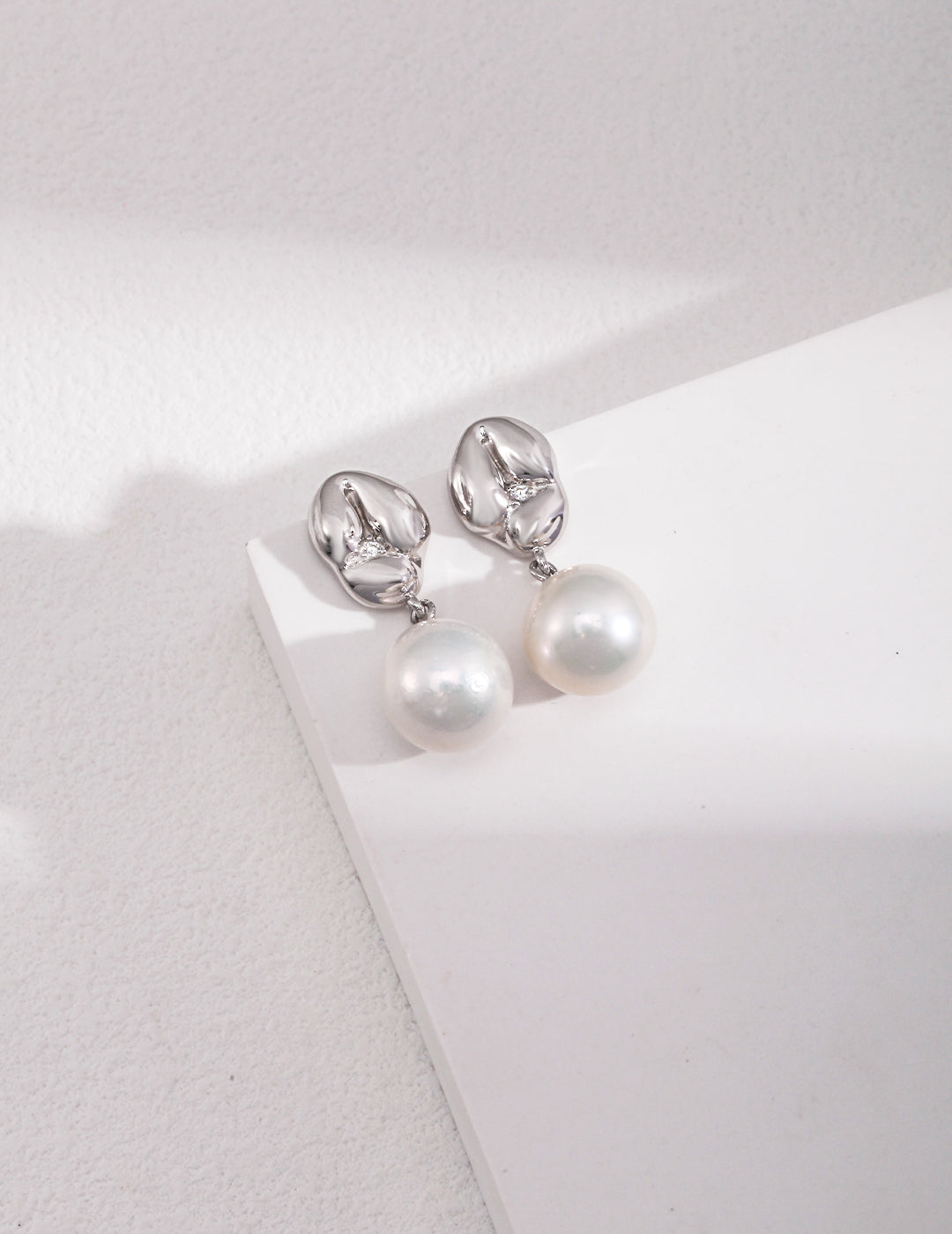 Sterling silver pearl earrings The slightly playful and cute earrings are like a piece of glutinous rice dumplings, and a shiny zircon is pressed down in the middle of the round bulge. Paired with natural baroque pearls, it is full of details and texture.