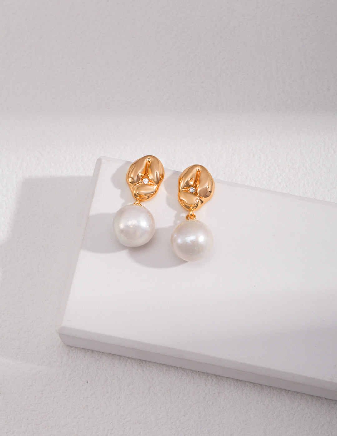 Sterling silver pearl earrings The slightly playful and cute earrings are like a piece of glutinous rice dumplings, and a shiny zircon is pressed down in the middle of the round bulge. Paired with natural baroque pearls, it is full of details and texture.